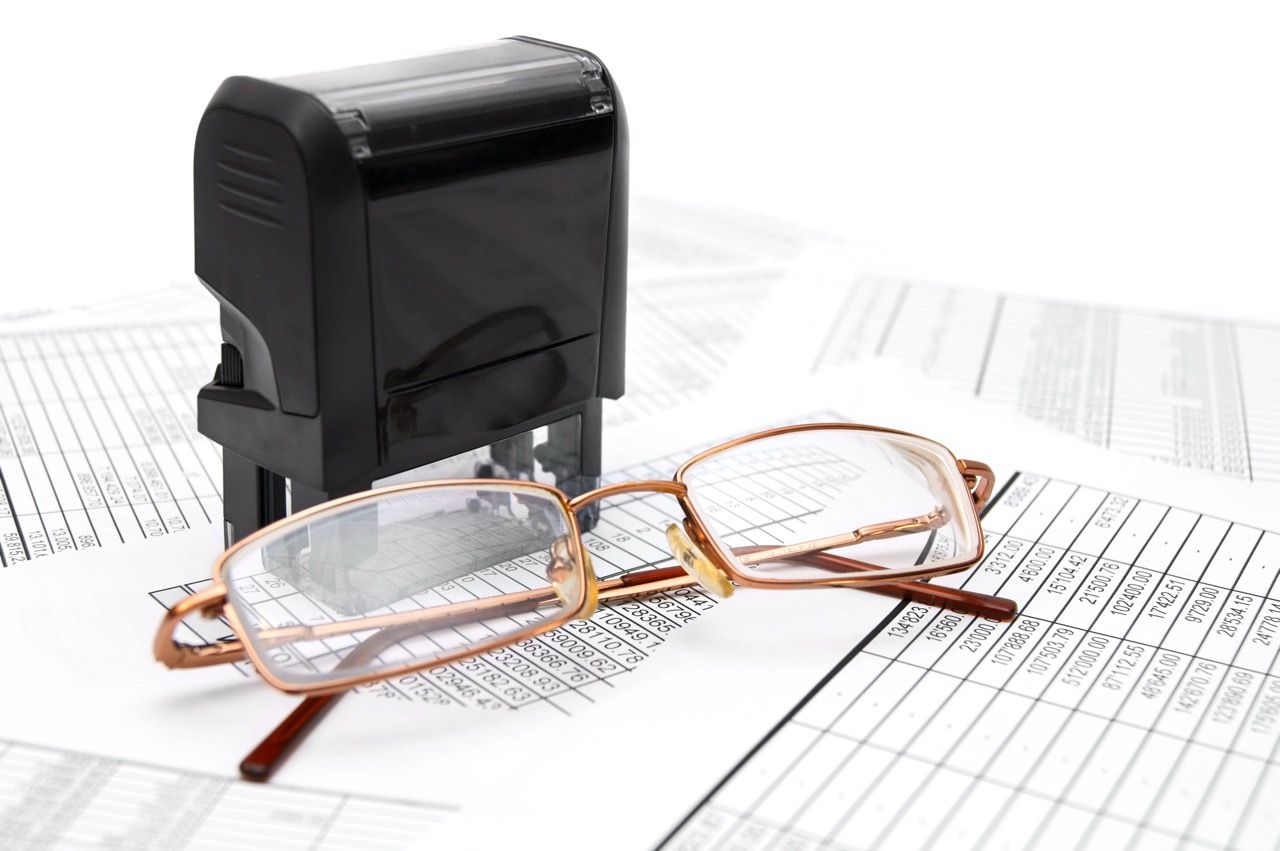 Press and glasses on documents. Compromiso con la Excelencia